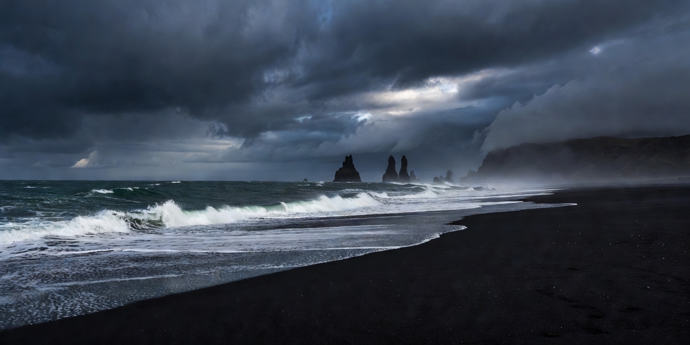 Black sand shoreline in Vik Iceland under moody sky