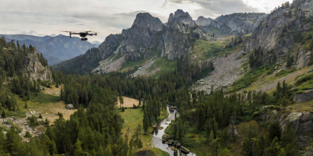 Cinematographer operating professional drone over mountain ridge